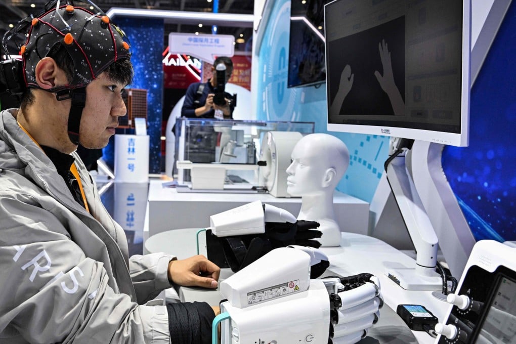 A man demonstrates a robotic hand with a brain-computer interface, which identifies the patient’s motor signals and controls the exoskeleton to move the limbs of the patient. Photo: AFP
