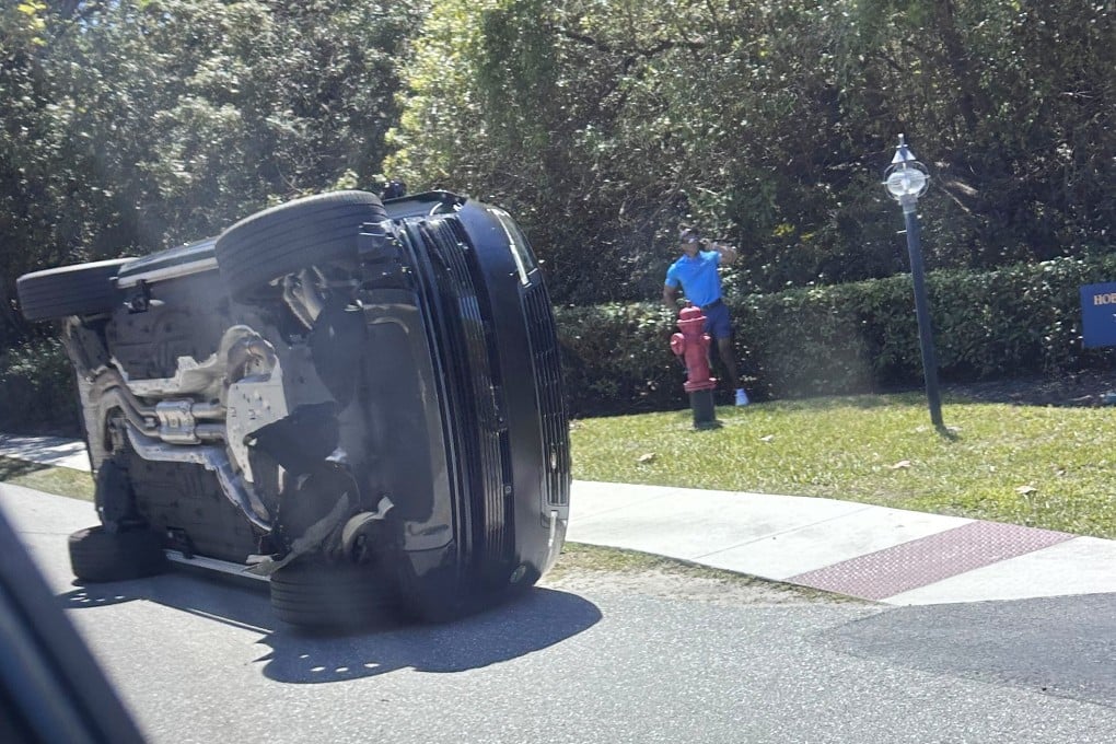 Tiger Woods stands by his overturned vehicle in Jupiter Island, Florida, on Friday. Photo: AP