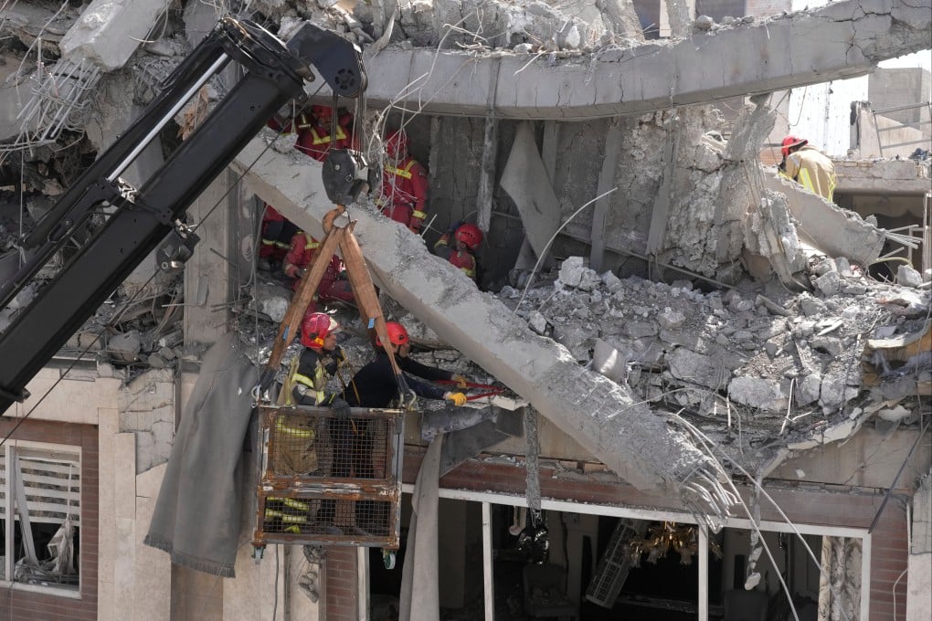 First responders work to remove a body from the rubble of a residential building hit in an overnight US-Israeli strike in Tehran on Friday. Photo: AP
