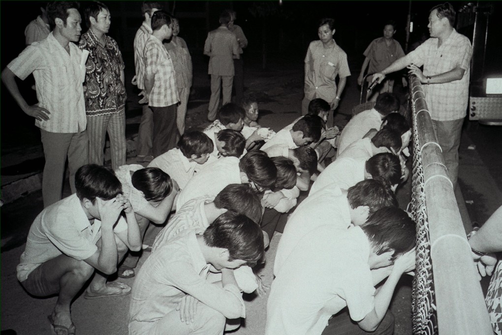 Suspected members of triad societies are guarded by officers in Tung Tau Estate, Kowloon, in 1973. Hong Kong’s triads have evolved from secret societies into global criminal networks. Photo: SCMP