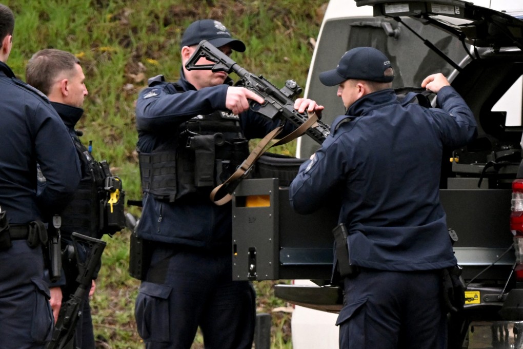 Armed police gather at a staging point near Porepunkah, Australia during a search for the fugitive linked to the murder of two police officers in August last year. Photo: AFP