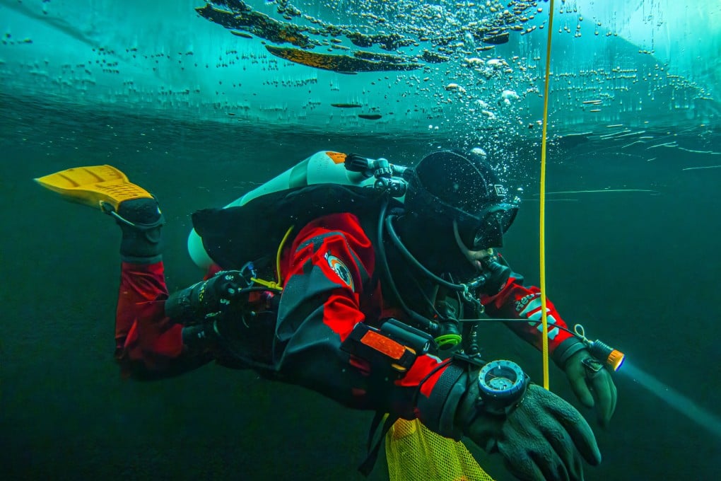 A diver swims under the ice during a Polar Scientific Diving class in Kilpisjarvi in Finland. Photo: AP