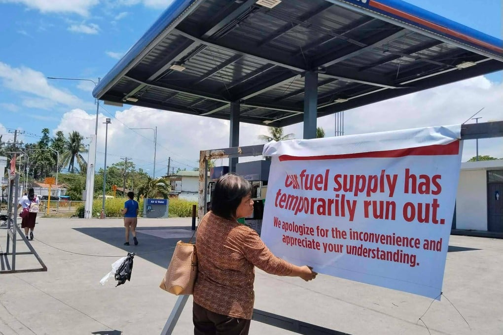 A pedestrian reads a sign at a petrol station in Tacloban City, Leyte province, central Philippines on Monday. Photo: AFP
