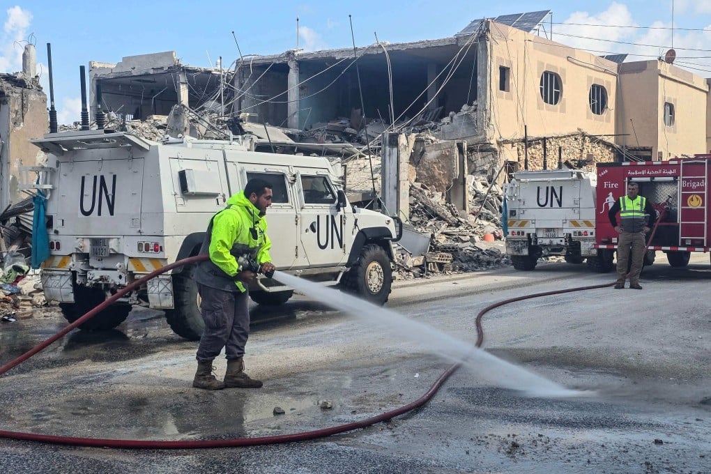 UN peacekeepers with the UN Interim Force in Lebanon drive past firefighters clearing the road at the site of an overnight Israeli airstrike in Naqura in southern Lebanon last week. Photo: AFP
