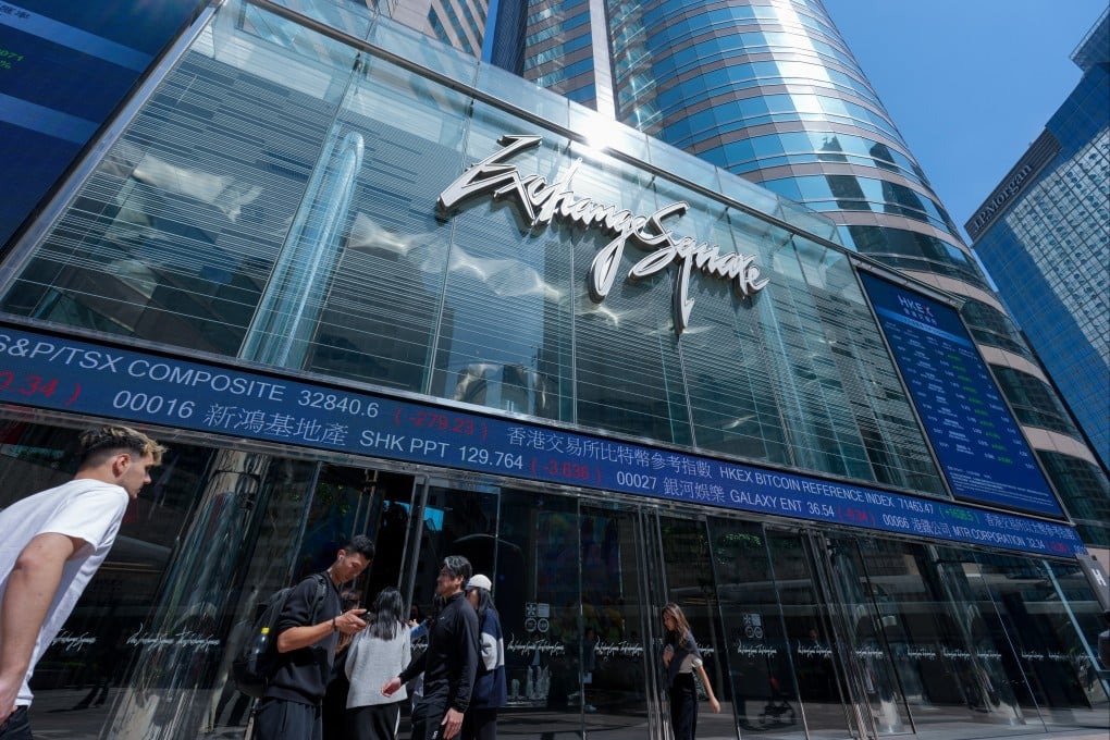 People walk past digital displays of stock market data outside the Hong Kong exchange in Central on March 13. Photo: Jelly Tse