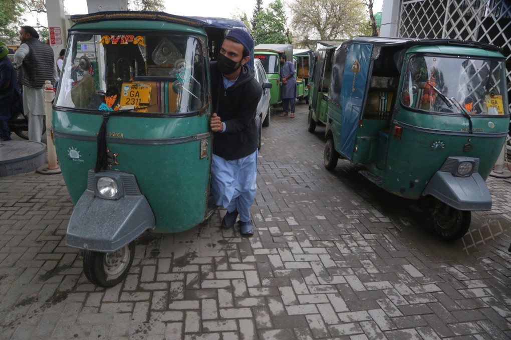 A driver pushes his auto rickshaw to get compressed natural gas at a filling station in Peshawar, Pakistan, as the government reduces the station’s working hours to save energy on March 18. Photo: AP