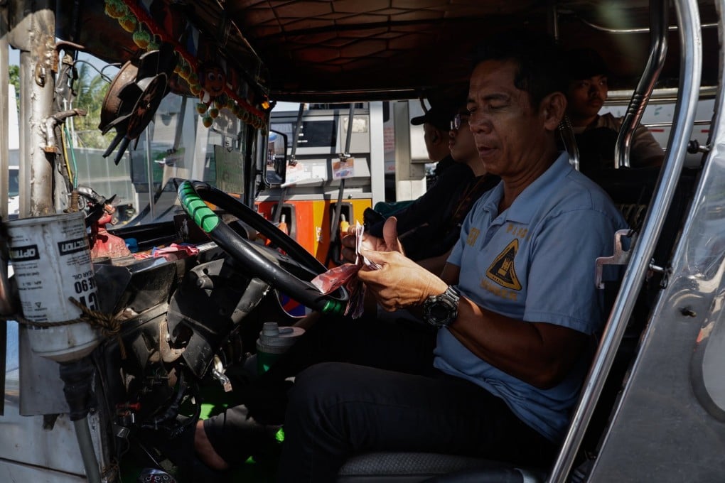 A jeepney, or local minibus, driver counts cash to pay at a fuel station in Quezon City, Metro Manila, Philippines, on March 25. Fuel shortages and increases in the cost of living can push vulnerable communities towards human traffickers. Photo: EPA