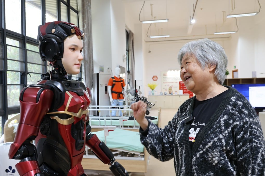 A senior resident interacts with ‘Xia Lan,’ a humanoid robot, at Shenzhen Nursing Home in Shenzhen, Guangdong province, March 3, 2025. Photo: Xinhua