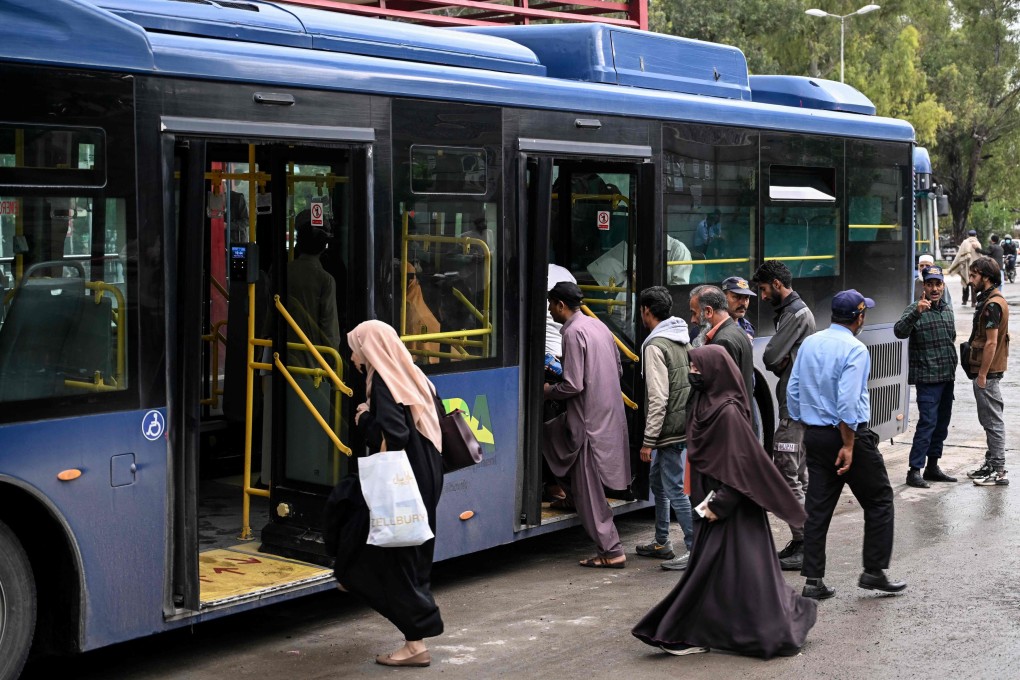 Passengers board a government bus in Islamabad on Friday. Photo: AFP