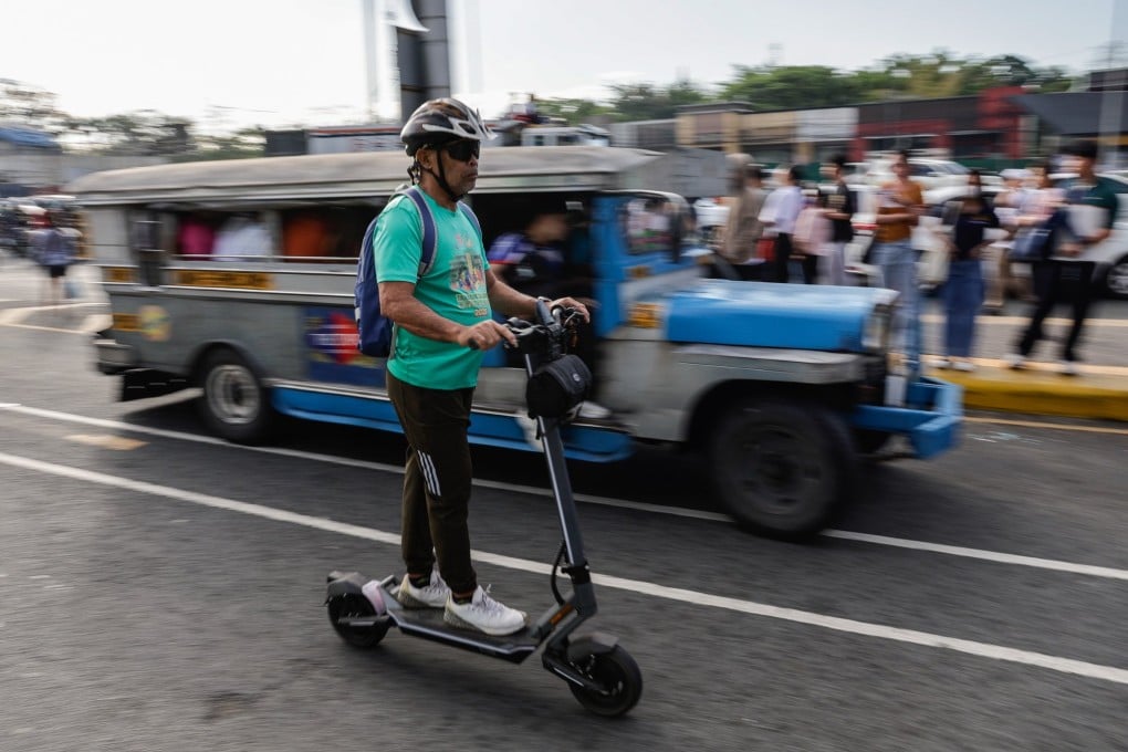 A person on an electric scooter passes a jeepney at a transport terminal in Quezon City on March 19. The Philippines is grappling with a national energy emergency triggered by the war in Iran. Photo: EPA