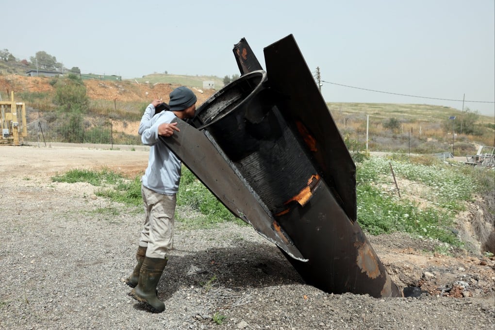 A Thai agricultural worker examines the tail of an Iranian ballistic missile that hit near a cow barn in the Israeli settlement of Shadmot Mehola, in the West Bank. Photo: EPA