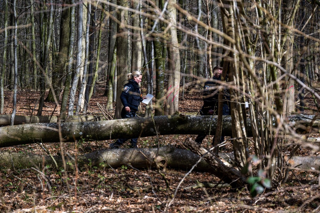 Police officers next to a fallen tree in woods south-east of Flensburg in Germany’s Schleswig-Holstein region on Sunday. Three people died when a tree fell during strong winds, police said. Photo: dpa