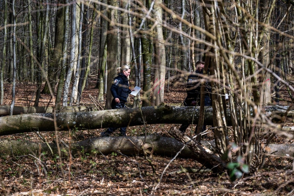 Police officers next to a fallen tree in woods south-east of Flensburg in Germany’s Schleswig-Holstein region on Sunday. Three people died when a tree fell during strong winds, police said. Photo: dpa