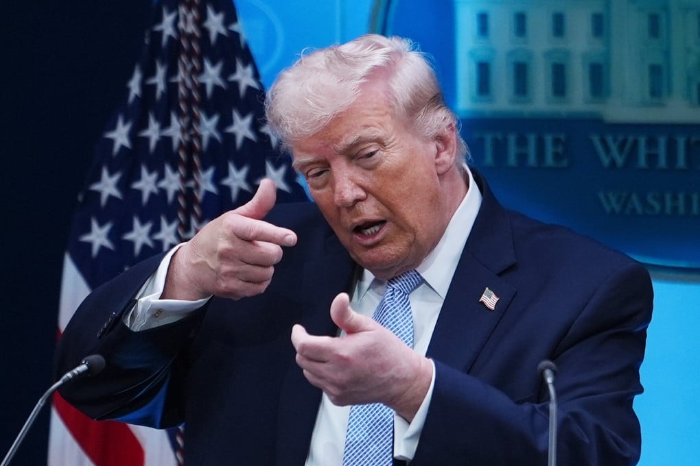 US President Donald Trump mimics aiming a sniper rifle while speaking with reporters at the White House on Monday. Photo: AP