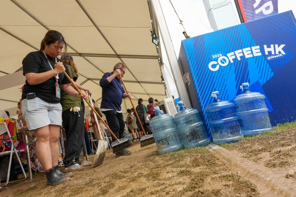 Staff clean up the muddy ground on the final day of the festival. Photo: Karma Lo