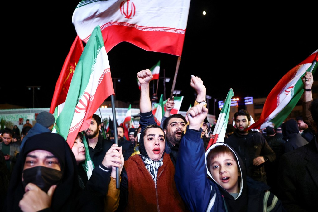 People wave flags as they celebrate the announcement of a two-week ceasefire in the Iran war in Tehran on Wednesday. Photo: WANA/Reuters