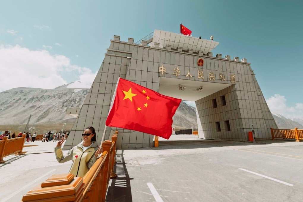 A visitor takes a photo at a China-Pakistan border crossing checkpost, high in the Karakoram Range in Xinjiang. Photo: EPA