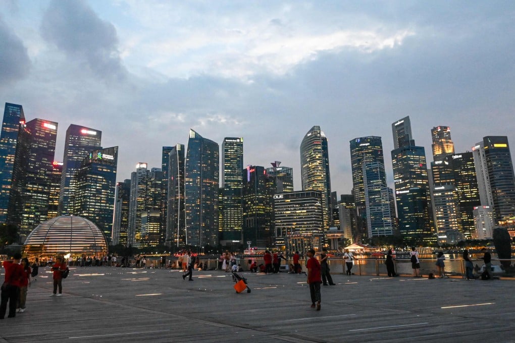 People gather along the boardwalk in front of the skyline at Marina Bay in Singapore. Photo: AFP