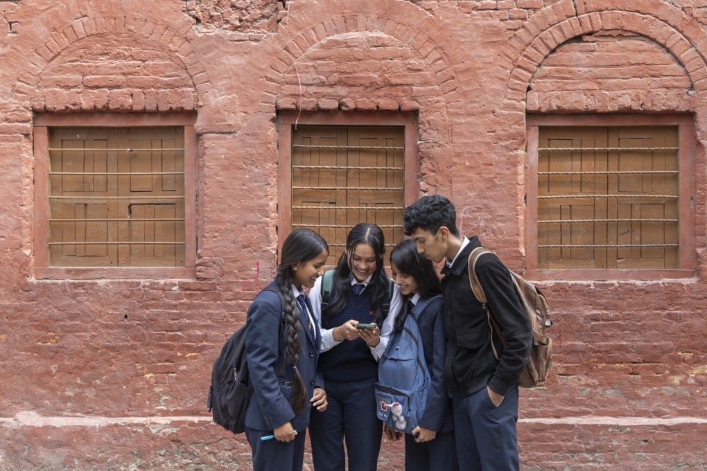 School students watch news about Balendra Shah, Nepal’s new prime minister, on a mobile phone in Kathmandu last month. Photo: EPA