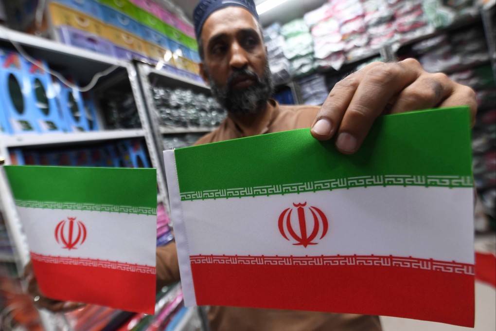 A shopkeeper displays Iranian flags after the US-Iran ceasefire announcement in Karachi, Pakistan, on Thursday. Photo: EPA