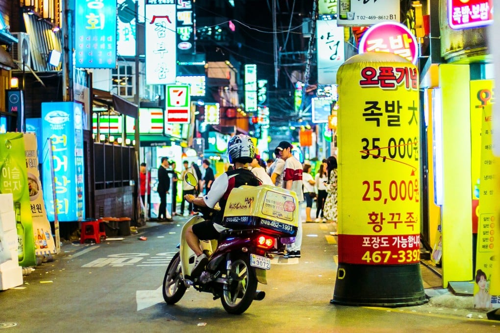 A delivery man makes his way on motorbike through Seoul’s busy Hongdae neighbourhood. Photo: Shutterstock