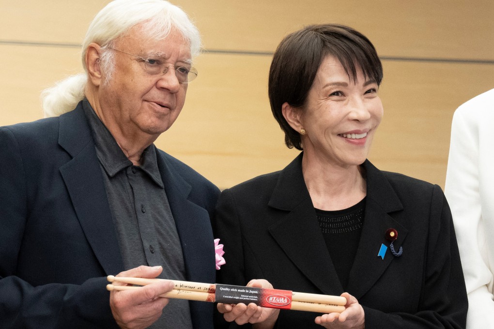 Japanese Prime Minister Sanae Takaichi gives Made-in-Japan drumsticks to Deep Purple drummer Ian Paice  at the Prime Minister’s Office in Tokyo on Friday. Photo: Reuters