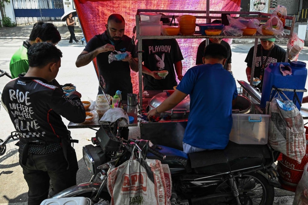 People eat braised beef stew locally known as “pares” at a stall in Manila, the Philippines, on April 7. Photo: AFP