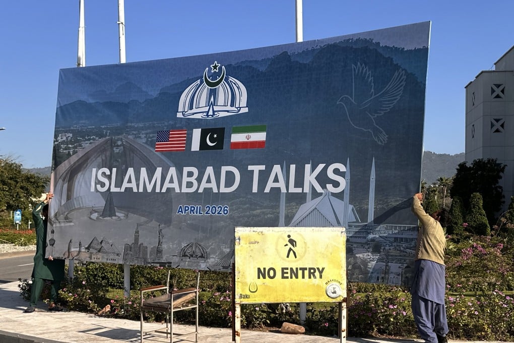 Workers remove a billboard after the failed peace talks between the United States and Iran, in Islamabad, Pakistan, on April 12. Photo: EPA