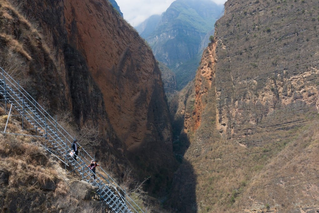 A family descends a steel ladder as they move to a new home in a community focused on poverty alleviation in Zhaojue county, Sichuan province, in May 2020. Photo: Xinhua