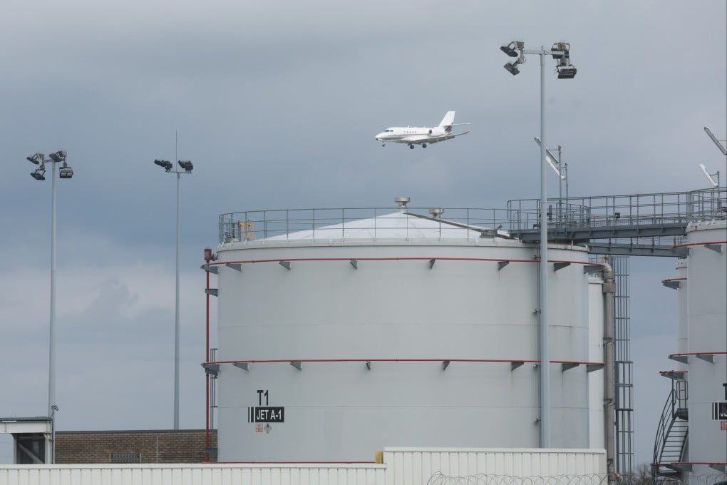 A plane passes behind kerosene storage facilities at Liege airport in Belgium on Thursday. Photo: EPA