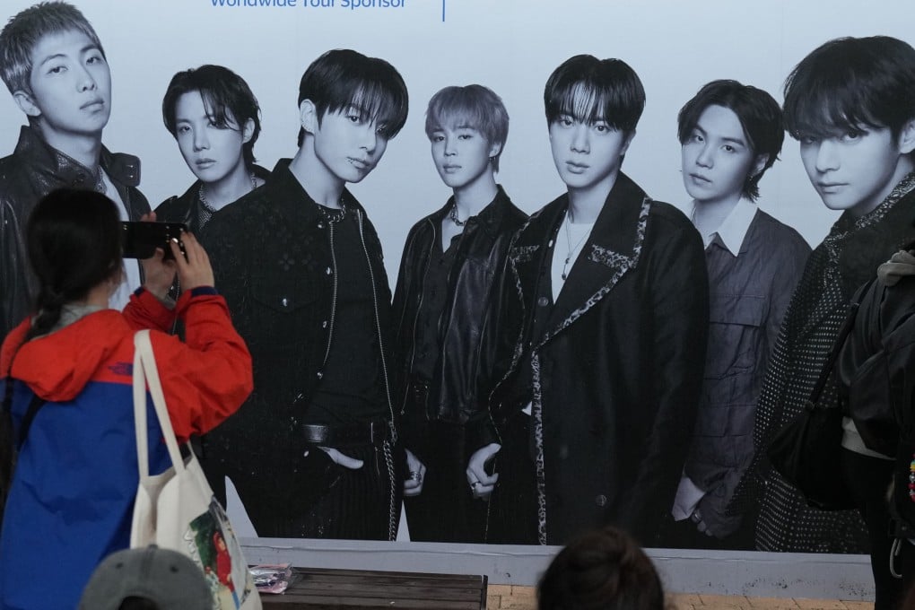 A BTS fan takes a photo of the band’s poster outside the stadium before the “Arirang” World Tour concert in Goyang, South Korea, on April 9. Photo: AP