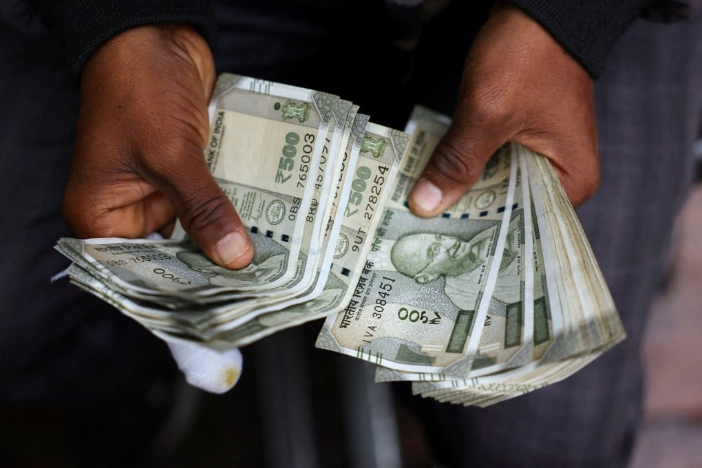 A man counts Indian rupee notes at a roadside currency exchange stall in the old quarters of Delhi on February 2. Photo: Reuters