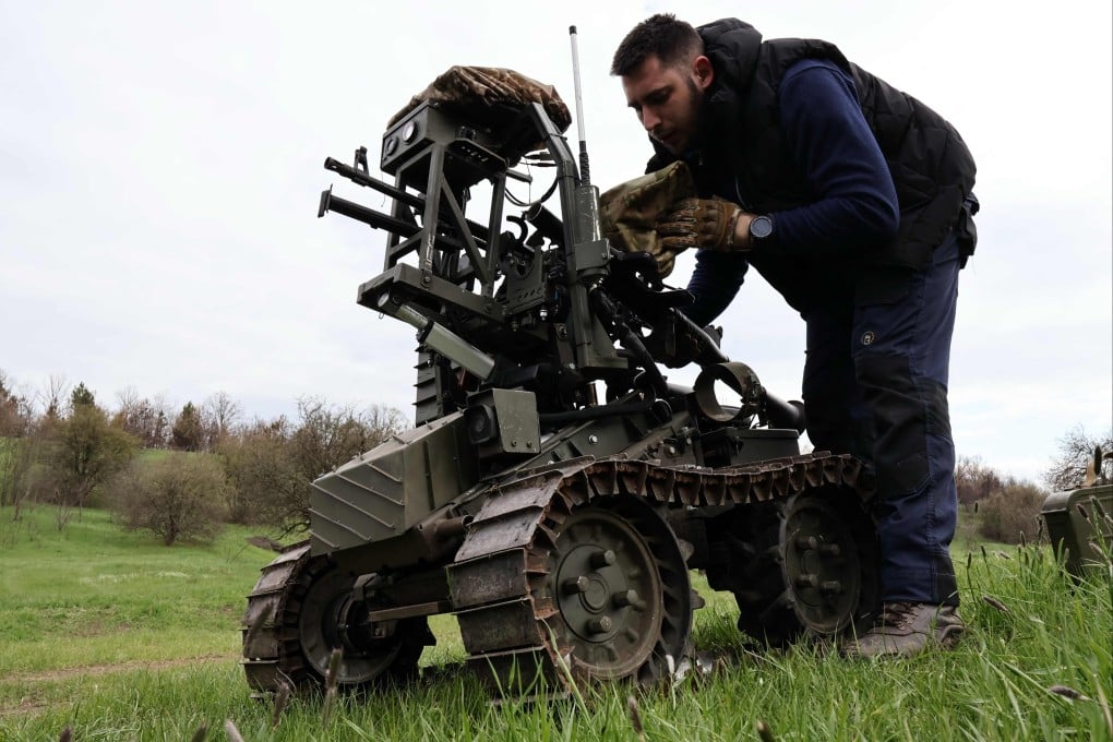 A Ukrainian serviceman prepares a machine gun on a combat ground drone during training. Ukrainian Armed Forces via AFP