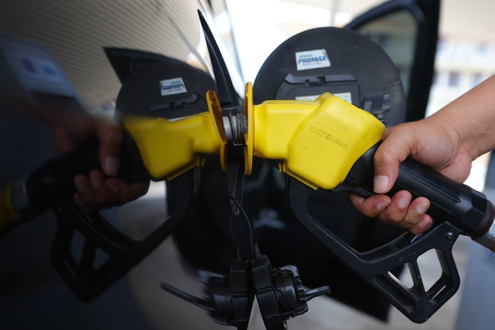 A man fills his car with RON95 petrol at a station in Malaysia on March 25. Photo: EPA