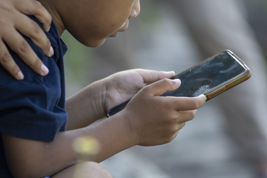 A child uses a mobile phone at a park in Denpasar, Bali, Indonesia, last month. Photo: EPA