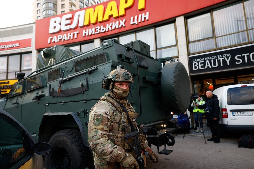 A Rapid Operational Response Unit member stands by an armoured vehicle outside a supermarket where the gunman barricaded himself in Kyiv on Saturday. Photo: Reuters