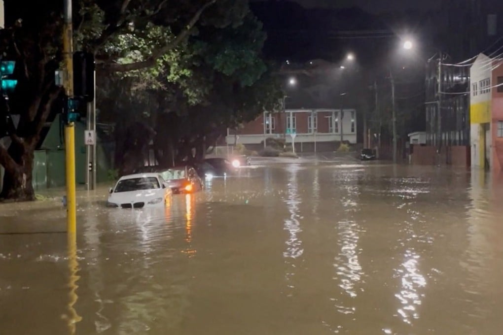 Vehicles can be seen partially submerged along a flooded road in Wellington, New Zealand, in a screengrab taken from a social media video on Monday, . Photo: Reuters