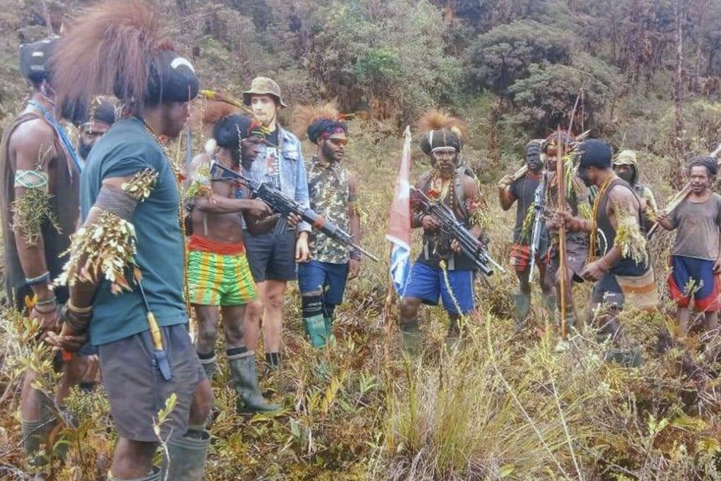 Papuan separatist rebels pose with Phillip Mark Mehrtens, whom they took hostage in February 2023. Photo: West Papua Liberation Army/AP