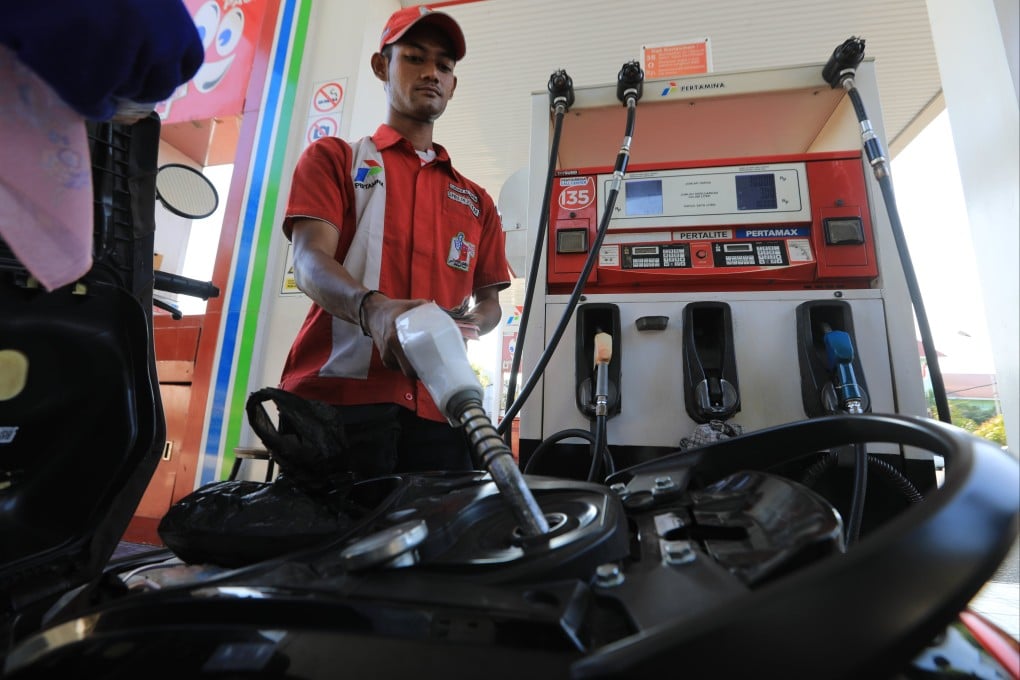 A worker refuels a motorbike at a petrol station in Banda Aceh, Indonesia, on Monday. Photo: EPA