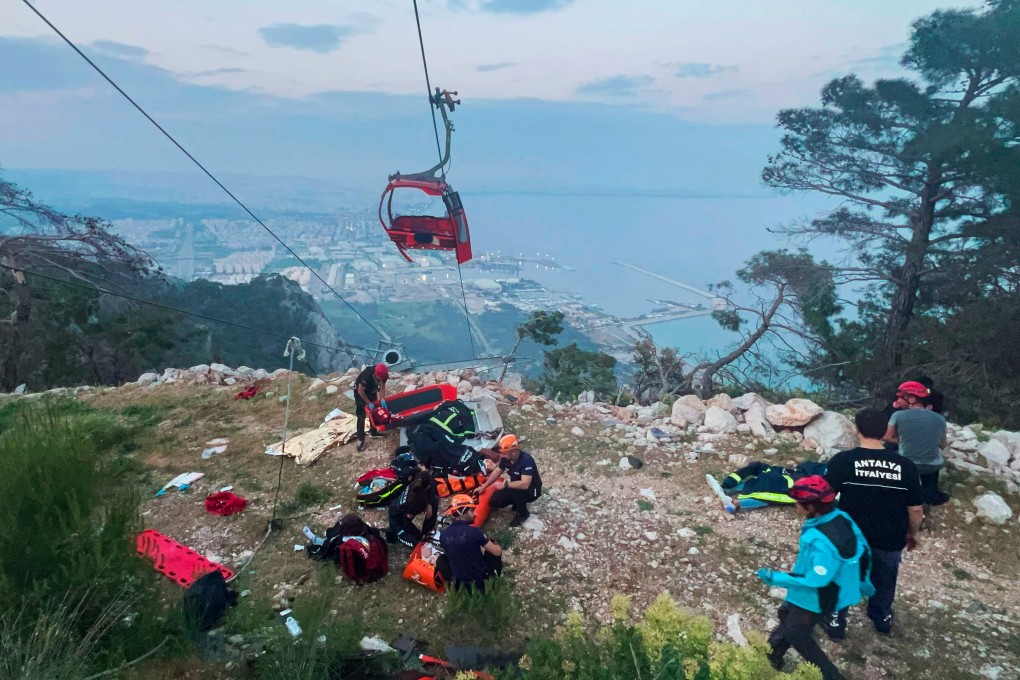 Rescuers work with passengers of a cable car outside Antalya, southern Turkey on April 12, 2024. On Monday, eight people were sentenced over the accident that killed a passenger and injured others. Photo: Dia Images via AP