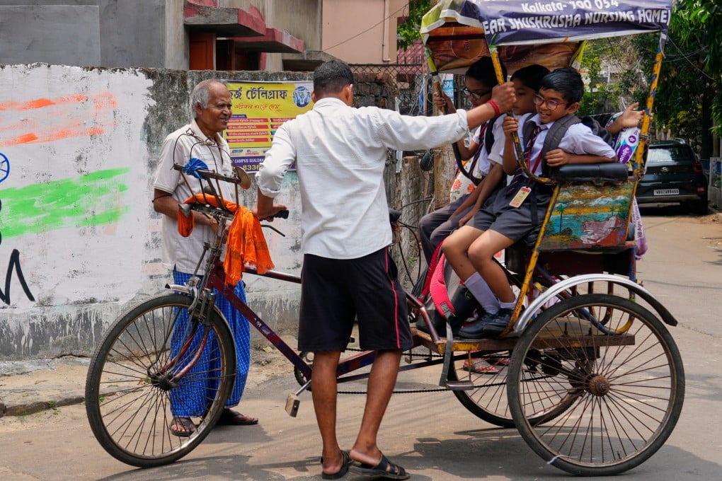 A tricycle rider transports school children home in Kolkata on Friday. Photo: AP