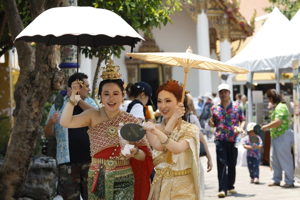 Tourists shield themselves from the sun with umbrellas at a temple in Bangkok, Thailand, on April 14. Photo: EPA