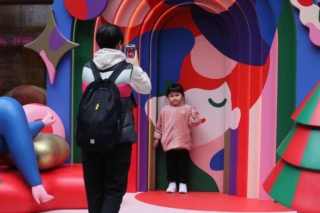 A child poses for a photo with a Christmas installation in Causeway Bay, Hong Kong. Photo: Xiaomei Chen