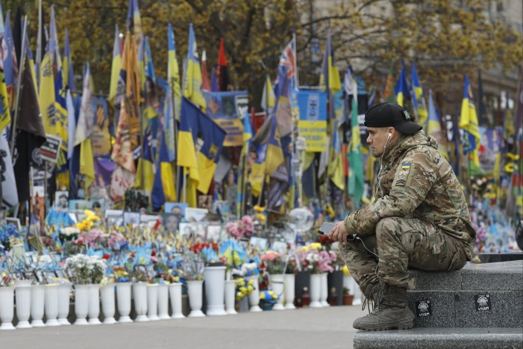 A man in military uniform sits near a makeshift memorial dedicated to the fallen Ukrainian soldiers and international volunteers in Independence Square in Kyiv, Ukraine on April 20, 2026. Photo: EPA