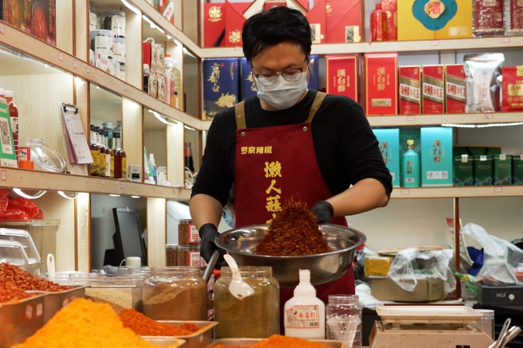 Luo Qi, the owner of Luo’s Chilli in Guiyang, Guizhou, weighs out chilli flakes for sale. Photo: Llewellyn Cheung