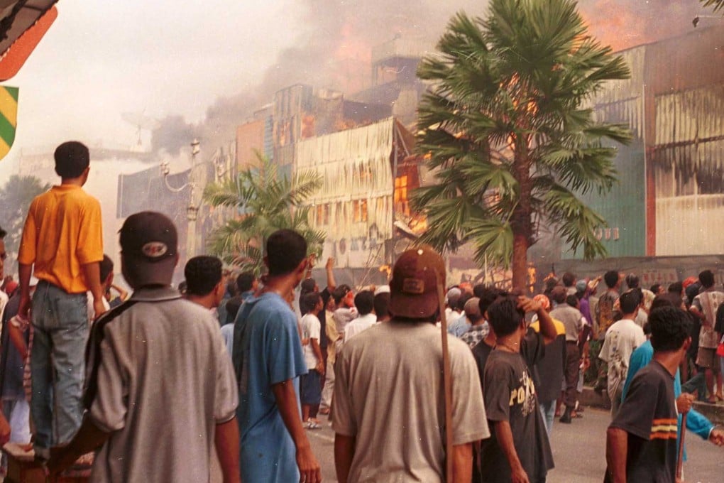 A crowd watched a burning shopping centre in Ambon in 1999 amid clashes between Christians and Muslims that had killed hundreds in the Indonesian city that year. Photo: Reuters