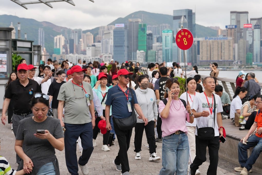 Tourists stroll along the waterfront in Tsim Sha Tsui. Photo: Karma Lo