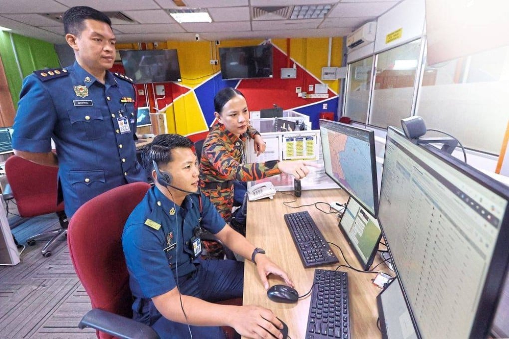 Johor Fire and Rescue Department fire operations management branch chief Winnie Kasing Jackson (standing) listening and directing fireman Mohd Shafrie Hussin at the agency’s operations room. Looking on is fire officer Muhammad Zaharul Asyraf Zaharin. Photo: The Star
