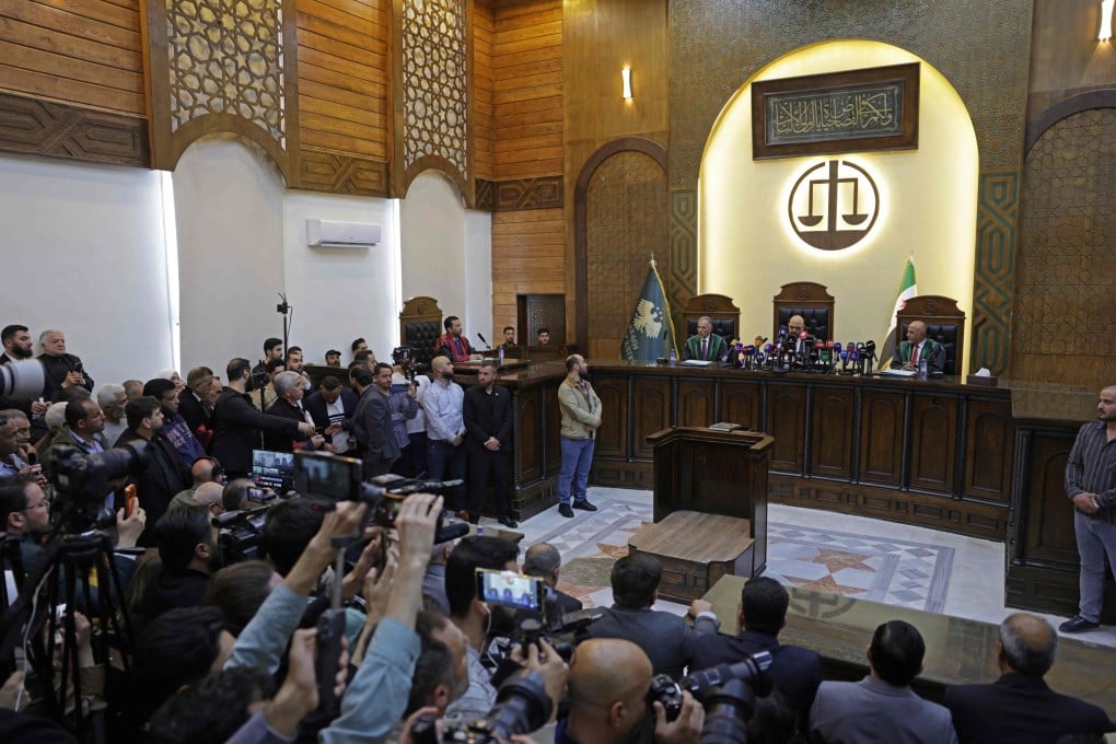 Judicial officials and people attend the first trial session at the Palace of Justice, in Damascus, Syria, on Sunday. Photo: AFP