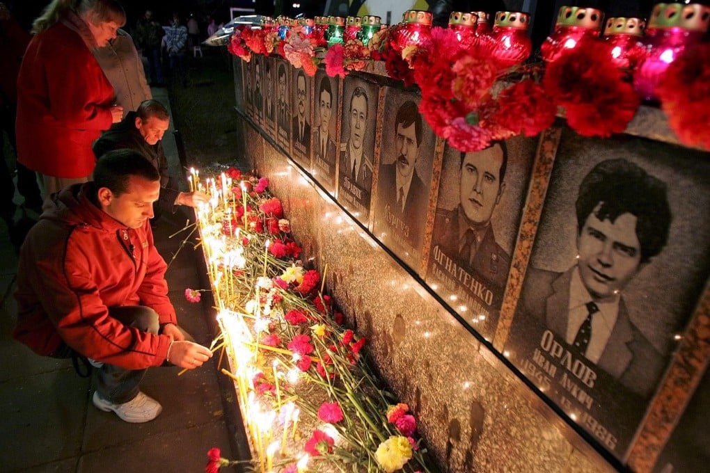 Ukrainians light candles at the memorial of dead liquidators who died during cleaning works after the Chernobyl nuclear power plant disaster, during a ceremony in Slavutych, Ukraine, in 2006. Photo: EPA